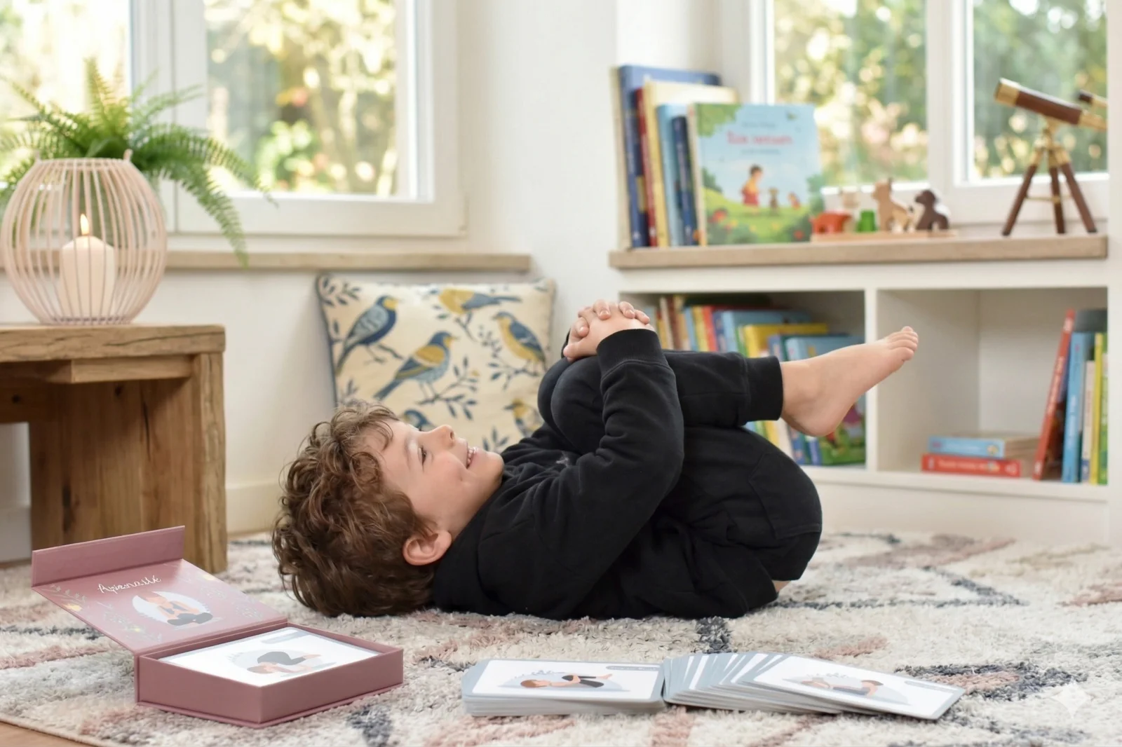 Junge lacht bei einer Yoga-Pose mit den Yomeda Kinderyoga Karten